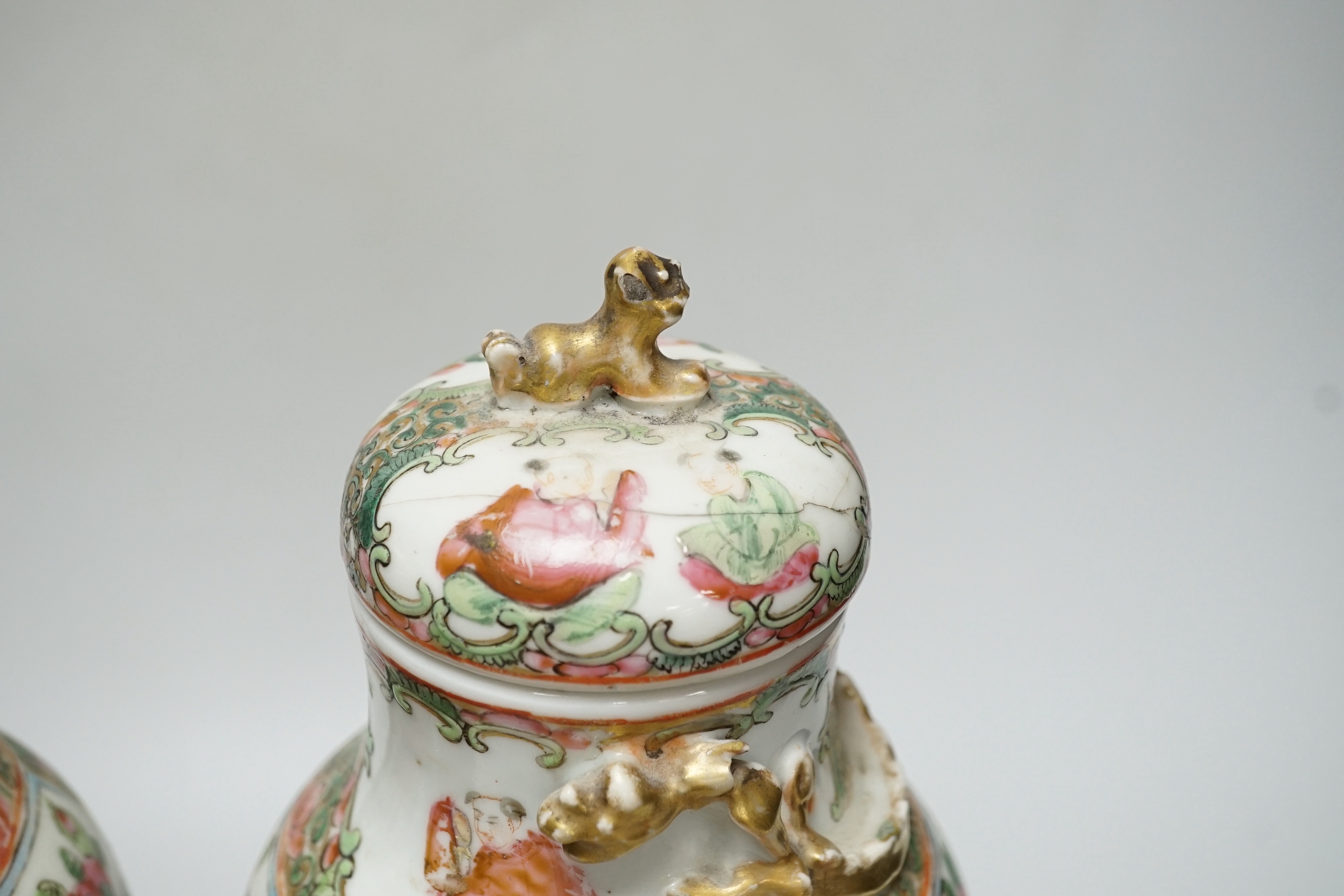 A pair of Chinese famille rose Canton baluster jars and covers with lion dog finials, 32cm high